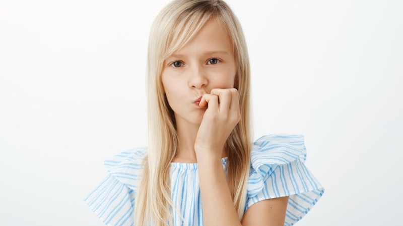 Девочка грызет ногти